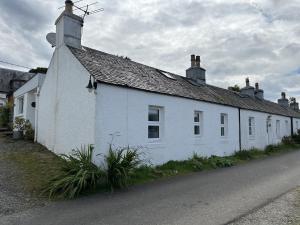 a white building on the side of a street at Mid- Village Croft in Cairndow