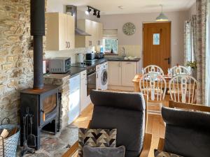 a kitchen with a wood stove in a room at Whispering Pines - Uk51248 in Swyre