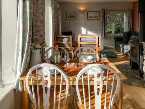 a dining room with a wooden table and chairs at Whispering Pines - Uk51248 in Swyre