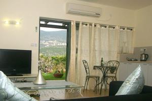 ein Wohnzimmer mit Fernseher und einem Tisch mit Stühlen in der Unterkunft צימורן in Moran