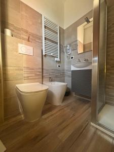 a bathroom with a toilet and a tub and a sink at Albergo Vecchio Pavone in Borgaro Torinese