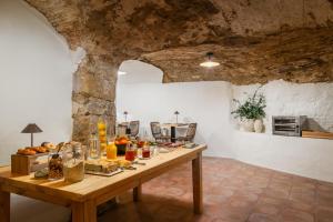 a table with food on it in a room with a stone wall at BYPILLOW Cluc Begur in Begur