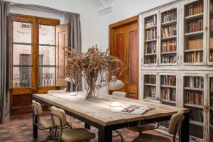 a dining room with a table and chairs and bookshelves at BYPILLOW Cluc Begur in Begur