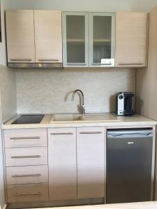 a kitchen with white cabinets and a sink at Vergos Hotel in Vourvourou