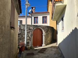 an alley with a red door in a building at Ancient village in Trieste