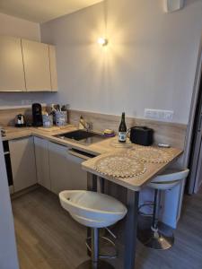 a kitchen with a sink and a table with a bottle of wine at Ty Joty in Perros-Guirec +7 photos
