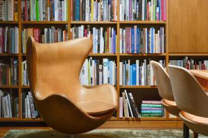 two chairs in front of a book shelf with books at GRAACE House Suites in Luxembourg