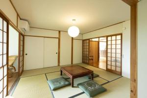 a living room with a table and some windows at 太宰府らたん - Dazaifu Ratan in Dazaifu