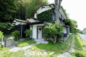 a house with a plant growing on the side of it at 太宰府らたん - Dazaifu Ratan in Dazaifu