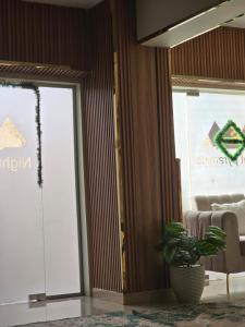 a room with a potted plant next to a glass door at Break pyramids inn in Al Manşūrīyah