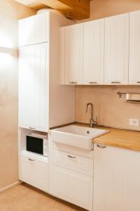 a white kitchen with white cabinets and a sink at Locanda dell'Ortolano in Ferrara