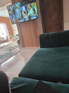 a living room with a couch and a flat screen tv at Break pyramids inn in Al Manşūrīyah