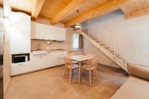 a kitchen with white cabinets and a table and chairs at Locanda dell'Ortolano in Ferrara +72 photos