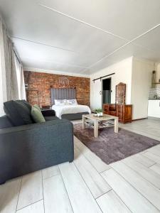 a living room with a couch and a bed at Cozy Cottage in Langebaan