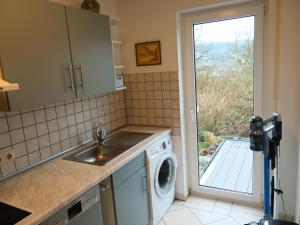a kitchen with a sink and a washing machine at Ferienwohnung Doris in Schmalkalden