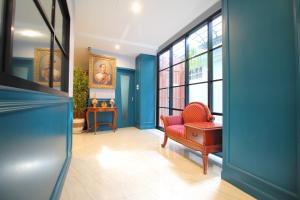 a living room with blue walls and a red chair at Super OYO 484 Pannee Residence Khaosan Sha Plus in Bangkok