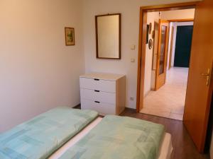 a bedroom with two beds and a dresser and a mirror at Ferienwohnung Doris in Schmalkalden