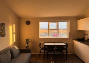 a living room with a couch and a table and a window at Faxaflatir Apartments in Hella