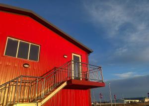 a red building with a staircase on the side of it at Faxaflatir Apartments in Hella