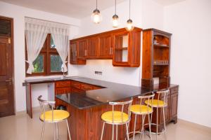 a kitchen with wooden cabinets and bar stools at Windsor Crest in Kandy +12 photos