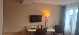 ein Zimmer mit einem Tisch und einem Fernseher an der Wand in der Unterkunft Hotel Pflug in Dornhan