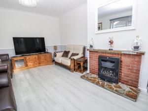 a living room with a fireplace and a tv at Red Brick Haven in East Cowes