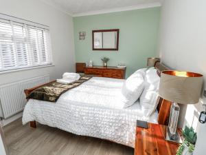 a bedroom with a white bed and a window at Red Brick Haven in East Cowes