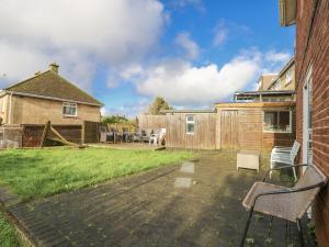 a patio with chairs and a fence and a house at Red Brick Haven in East Cowes