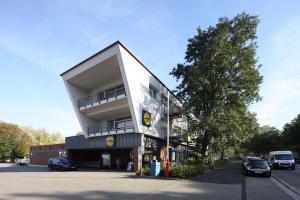 a tall building with a balcony on the side of a street at Petul Apart Hotel City in Essen