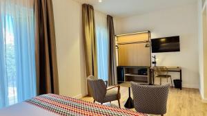 a hotel room with a bed and two chairs at Hotel Doho in Málaga