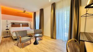 a hotel room with a bed and a table and chairs at Hotel Doho in Málaga