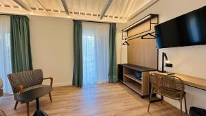 a living room with two chairs and a flat screen tv at Hotel Doho in Málaga
