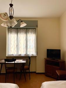 a room with a table and a window with a television at appartamento Graziana in San Bonifacio