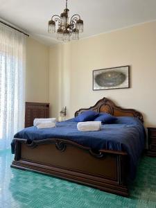 a bedroom with a bed with blue sheets and a chandelier at appartamento Graziana in San Bonifacio