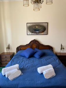 a bedroom with a blue bed with two towels on it at appartamento Graziana in San Bonifacio