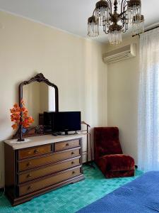 a bedroom with a dresser with a mirror and a chair at appartamento Graziana in San Bonifacio