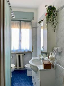 a white bathroom with a sink and a toilet at appartamento Graziana in San Bonifacio +6 photos