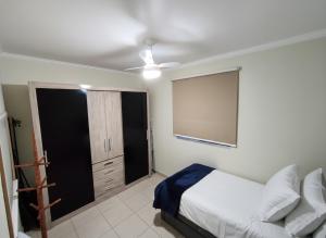 a bedroom with a bed and a ceiling fan at Apto 2Q Centro Wifi Shopping Garage in Taubaté