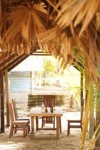 a wooden table and chairs in a patio with a table and benches at Beach View Resort in Batticaloa