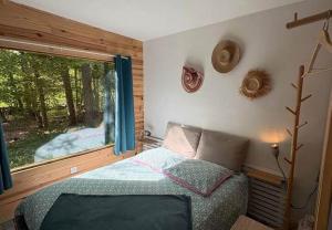a bedroom with a bed and a large window at Domaine de la Mamounette in Champclause