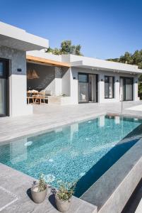 a swimming pool in front of a house at Villa Helena in Paleros