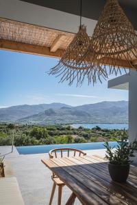 a wooden table and bench on a patio with a view at Villa Helena in Paleros
