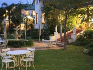 a table and chairs in the yard of a house at Riebeek Valley Hotel in Riebeek-Wes
