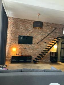 a living room with a couch and a brick wall at Apartament Kołobrzeska in Piła