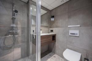 a bathroom with a shower and a toilet and a sink at Postillion Utrecht Bunnik in Bunnik