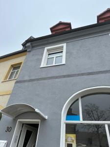 a gray building with white windows and a sign on it at Monteurunterkunft nahe Tor 1 in Leuna