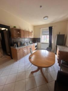 a kitchen with a wooden table and a kitchen with a refrigerator at Monteurunterkunft nahe Tor 1 in Leuna