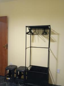 a shelf with two stools in a room with a wall at Casa três com cozinha americana in Araruama