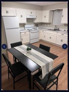 a kitchen with white cabinets and a table with chairs at Heavenly Home in Monroe