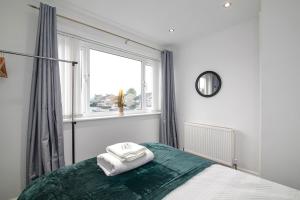 a bedroom with a bed with two towels on it at Contractor Accommodation, Free Large Car Park, Sleeps 7 in Kent +7 photos